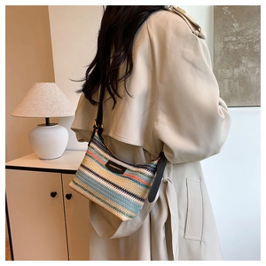 Close-up of bohemian woven shoulder bag with colorful stripes and leather label