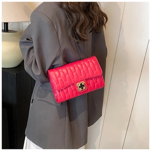 Detail of rose red quilted bag with gold flower buckle and metal chain strap