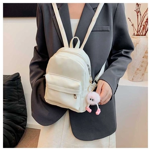 Mini sac à dos blanc en similicuir avec porte-clé peluche rose porté par un mannequin