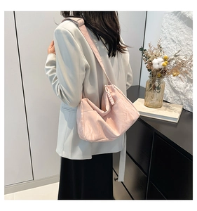 Detail of light pink crossbody tote bag with soft texture and wide shoulder strap