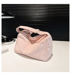 Detail of pink nylon shoulder bag with adjustable strap and woven zipper puller
