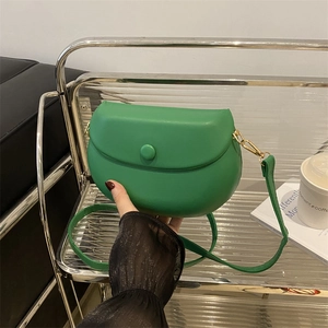 Vibrant green minimalist saddle bag with gold metal hooks and round buckle closure