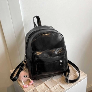 Sac à dos minimaliste en cuir PU noir brillant avec un pendentif pompon rose doux