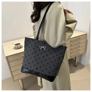 Detail of grey canvas tote bag featuring black polka dots and silver bow decoration