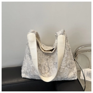 Detail of white butterfly tote bag featuring feathered texture and faux leather straps
