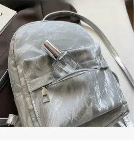 Detailed top view of a mini velvet backpack with silver zippers and compact front pocket