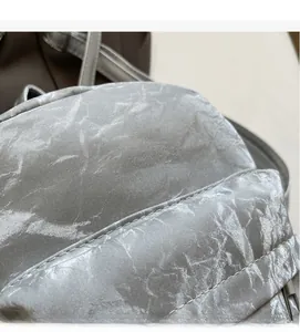 Macro shot of silver gray silky velvet backpack showing fine stitching and metallic texture