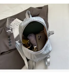 Detailed interior view of a silver mercerized velvet mini backpack showing its storage capacity