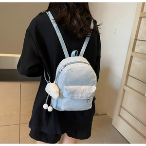Close-up of light blue mini backpack showing detailed crinkled texture and cloud charm