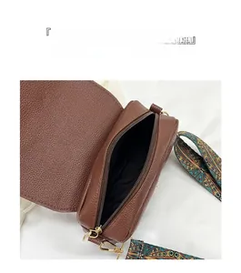 Detail view of ethnic strap crossbody bag with lychee leather and gold hardware