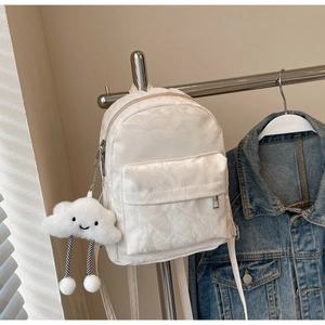 Detail van witte mini-rugzak met geplooide textuur en schattige wolk pluche hanger