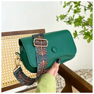 Detail of vintage emerald crossbody bag with wide ethnic geometric patterned strap