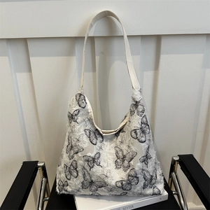 Minimalist white canvas tote bag with black textured butterfly print and fringe details