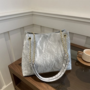 Silver metallic pleated tote bag with chain strap and embossed FASHION lettering