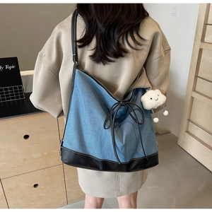 Blue denim hobo bag featuring black leather trim and cute plush cloud charm