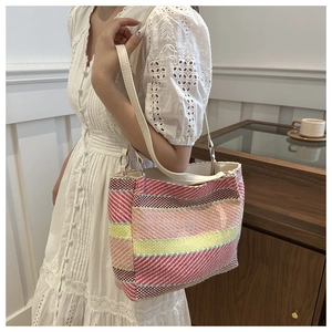 Détail d'un sac cabas tissé à rayures colorées avec bandoulière en cuir crème chic