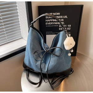 Detailed view of blue denim butterfly tote bag with black leather straps and cloud pendant