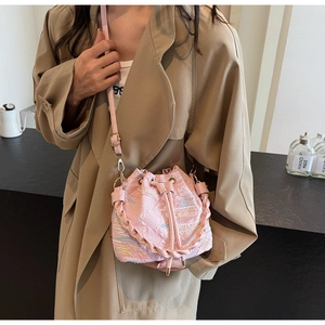 Detail of pink drawstring bucket bag with textured quilted fabric and colored stitching