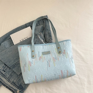 Light blue tote bag with embossed textures and colorful wavy stripes for summer 2024