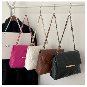 Detailed view of quilted chain bags in magenta, white, brown and black colors