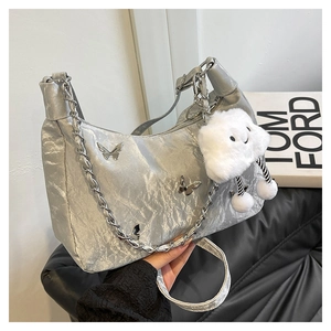Detail of silver metallic crossbody bag with butterfly accents and plush cloud charm