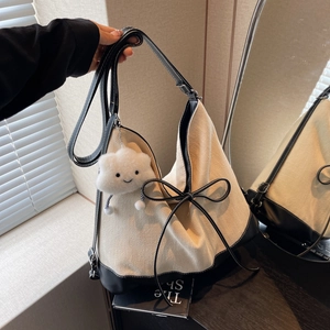 Large beige canvas tote bag with black leather trim and cute plush cloud keychain