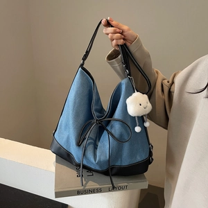 Denim blue canvas tote bag with black leather trim and cute white cloud keychain