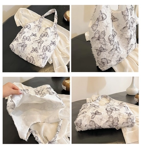 Detailed close-up of a white tote bag with textured butterfly prints and spacious interior