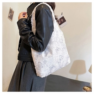 Close-up of the intricate butterfly embroidery and lace texture on the white tote bag