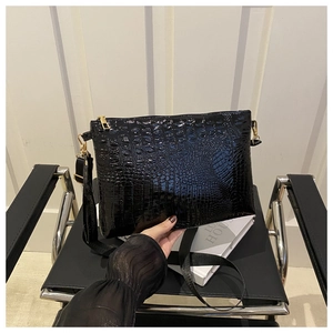 Close-up of black crocodile pattern embossing and gold zipper on a large tote bag