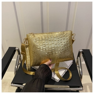 Detailed view of the metallic gold crocodile pattern surface and high-quality gold hardware
