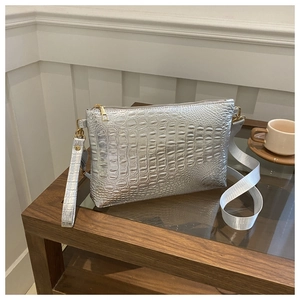 Detail of silver crocodile pattern texture on luxury PU leather with gold hardware