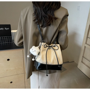 Detail of canvas drawstring bucket bag featuring black base contrast and cloud charm