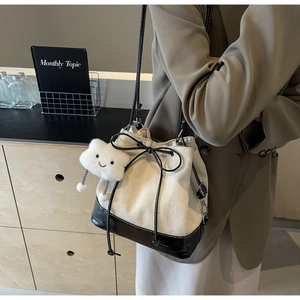 Detail of drawstring bucket bag with canvas stitching and cute cloud plush charm
