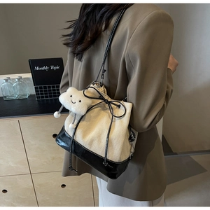 Detail of canvas bucket bag featuring herringbone pattern and plush cloud charm