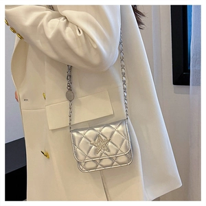 Close-up of silver quilted crossbody bag with star rhinestone and metal chain