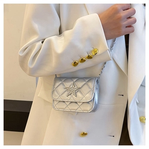 Detail of silver quilted mini bag with sparkling diamond star and metal chain strap
