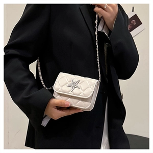Detail of mini quilted crossbody bag featuring a crystal star buckle and chain strap