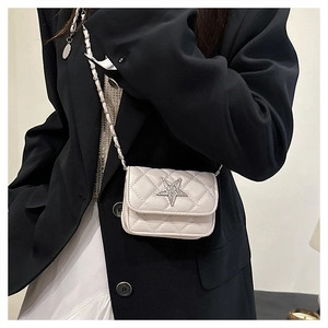 Close-up of white quilted mini bag with diamond star detail and chain strap