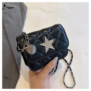 Close-up of quilted mini bag with a large silver rhinestone star and woven chain strap