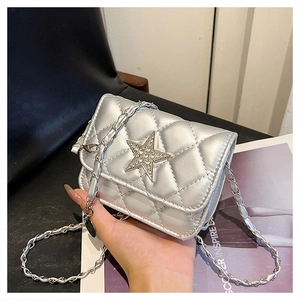 Close-up of silver quilted crossbody bag with a sparkling diamond star metal ornament