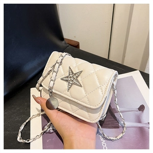 Close-up of white quilted mini bag featuring a sparkling crystal-encrusted star ornament