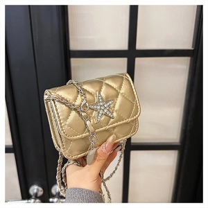 Close-up of a mini gold quilted crossbody bag featuring a sparkling rhinestone star