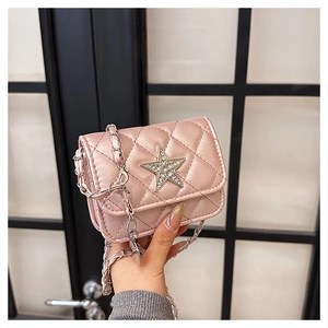 Detail of pink quilted mini crossbody bag with crystal star clasp and metal chain strap