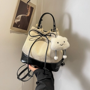Women's minimalist herringbone bucket bag with black leather trim and plush cloud charm