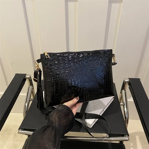 Chic black crocodile embossed envelope bag with gold hardware and a shoulder strap