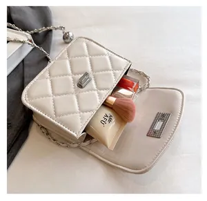 Detailed view of white quilted crossbody bag interior with silver chain and metal clasp