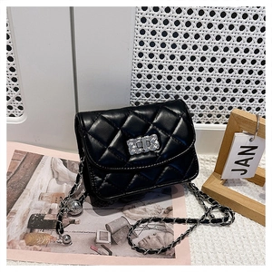 Close-up of black quilted leather texture and silver rotating lock on crossbody bag