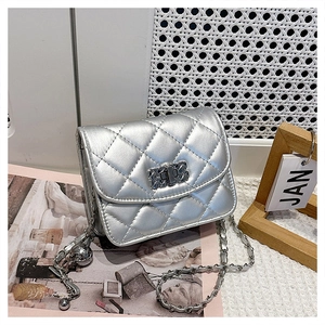 Detail of silver metallic quilted crossbody bag showing chain strap and twist lock