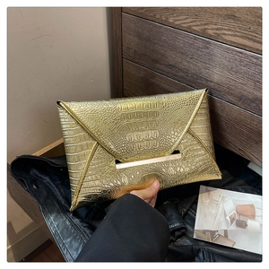 Detailed view of gold crocodile pattern envelope clutch with metal trim and PU leather